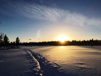 Scenic view of snow field against sky during sunset