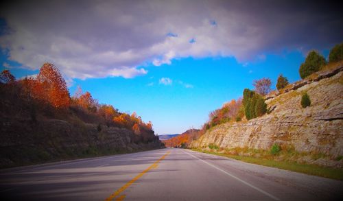 Empty road with trees in background