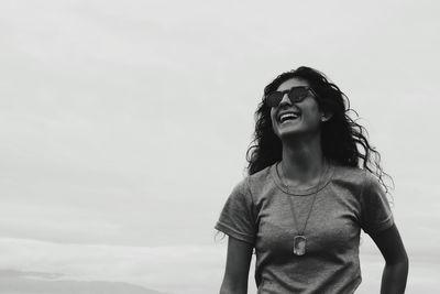 Smiling young woman against sky