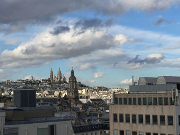 Buildings against cloudy sky