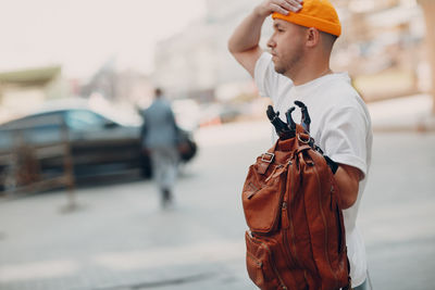 Side view of man holding umbrella standing on street