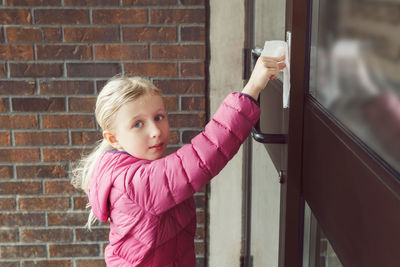 Girl with napkin pressing doorbell