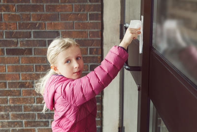 Girl with napkin pressing doorbell