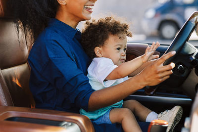 Midsection of woman using mobile phone while sitting in car