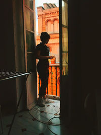 Backlighting of woman standing in balcony