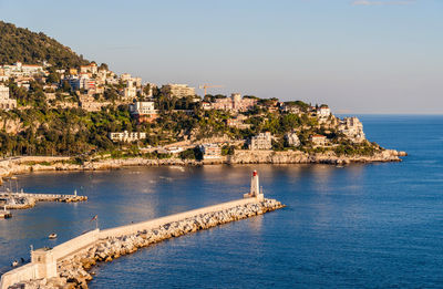 Aerial view of town by sea against sky