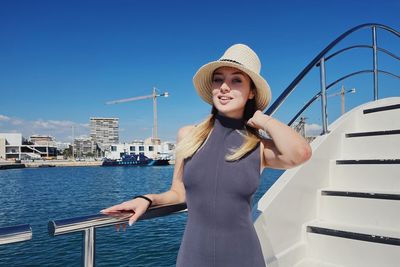 Portrait of smiling young woman standing in city