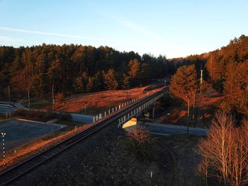 Railroad track amidst trees against sky during autumn