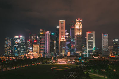 Illuminated buildings in city against sky at night
