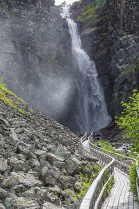 Long hiking footbridge to a waterfall in a canyon