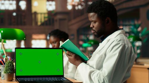Side view of man using laptop at cafe