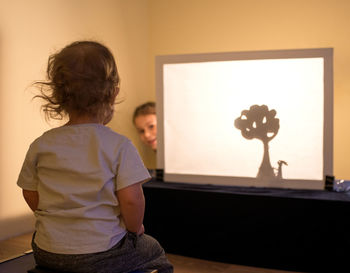 Rear view of woman standing at home
