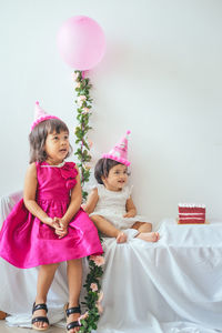 Portrait of cute girl with pink balloons