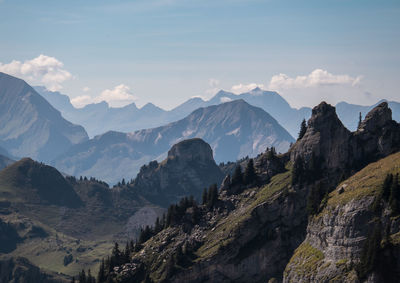 View of rocky mountains against cloudy sky