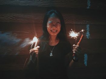 Young woman holding burning candle