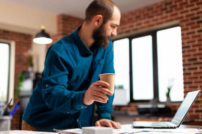 Businessman holding coffee cup at office