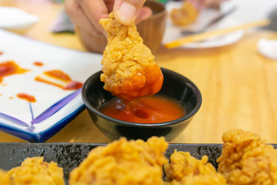 Cropped hand of person preparing food on table