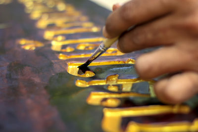 Close-up of person working on metal