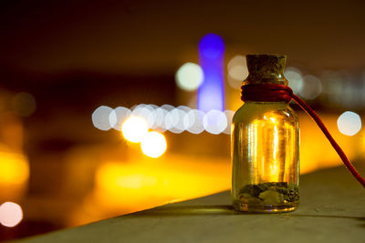 Glass bottle on table at night
