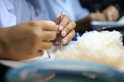 Cropped hands holding tweezers in home