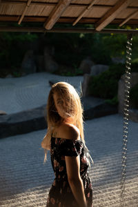 Portrait of young woman standing against trees