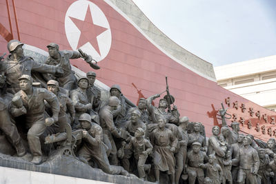 Low angle view of statues against sky in city