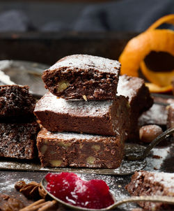 Baked square pieces of chocolate brownie sprinkled with powdered sugar on the table