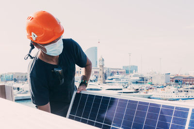 Man working with arms raised against sky