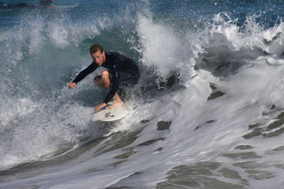 Young man splashing water in sea