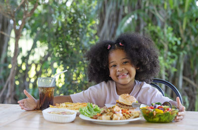 Portrait of smiling boy eating food on table