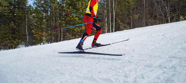 Low angle view of man skiing on snow covered field