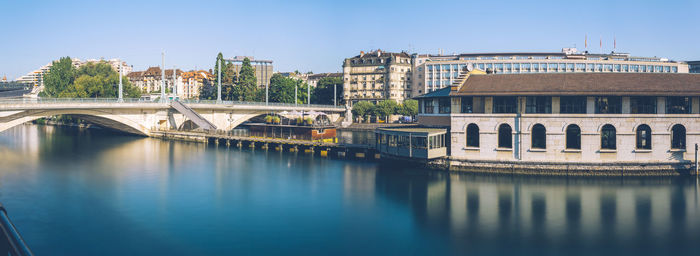 Bridge over river in city against clear sky