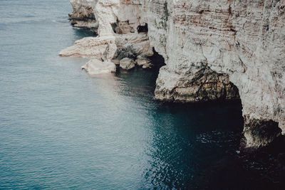 Rock formations by sea against sky