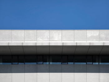 Low angle view of modern building against clear blue sky