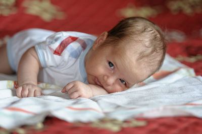 Portrait of cute baby lying on bed