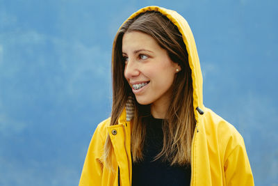 Portrait of young woman standing against sky