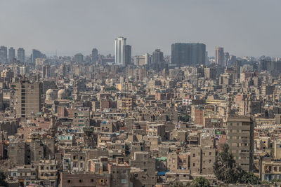 Aerial view of buildings in city against sky