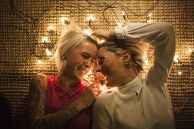 Two friends lying on the floor with fairy lights