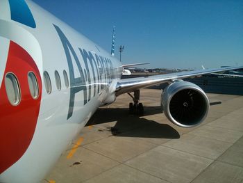 Airplane on airport runway against clear blue sky