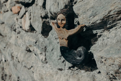 Damaged boat on rock against wall