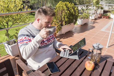 Portrait of senior man using mobile phone while sitting at restaurant