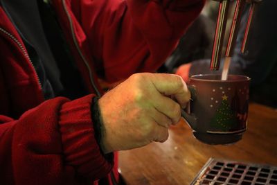 Midsection of man holding glühwein cup