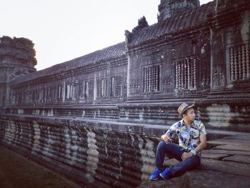 Full length of man sitting outdoors