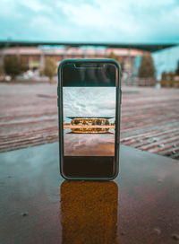 Close-up of smart phone on street