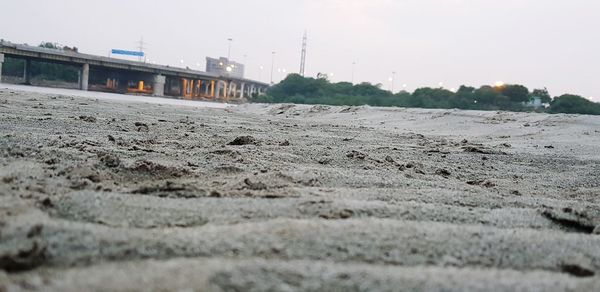 Surface level of sandy beach against sky