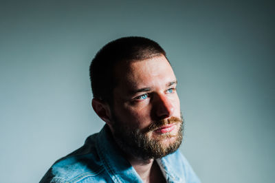 Close-up portrait of man against gray background