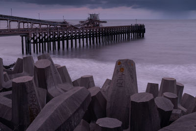 Pier over sea against sky during sunset