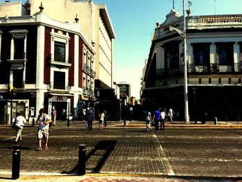 People walking on road along buildings