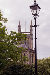 Low angle view of street light by building against sky