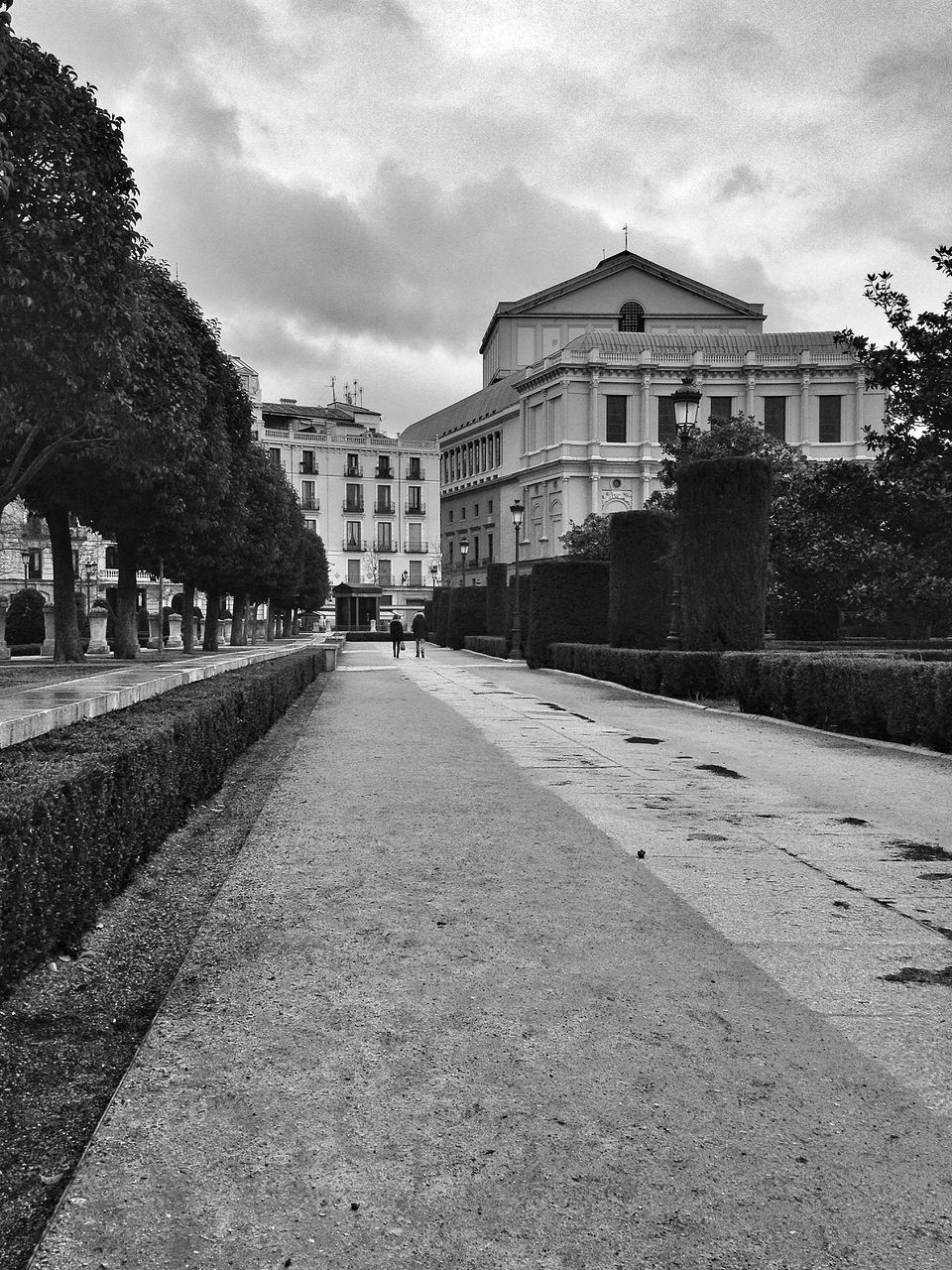 building exterior, architecture, built structure, sky, the way forward, cloud - sky, street, diminishing perspective, road, cloudy, cobblestone, transportation, tree, cloud, vanishing point, city, outdoors, surface level, incidental people, empty